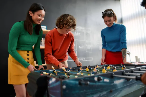 Happiness at Work. Group of young and happy web designers in casual wear playing table soccer in the creative office. Office activities. Having fun together. Happy employees — Φωτογραφία Αρχείου