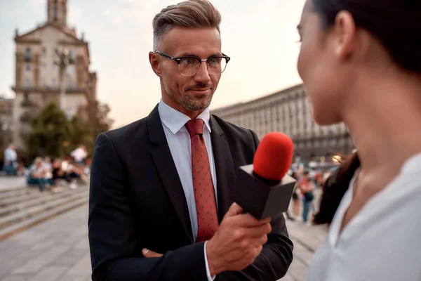 First. Best. Live. Professional reporter interviewing woman on urban street. Journalism industry, live streaming concept — Stockfoto