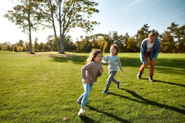 Construyendo cuerpos y mentes fuertes. Familia emocionada divirtiéndose al aire libre en un día soleado — Foto de Stock