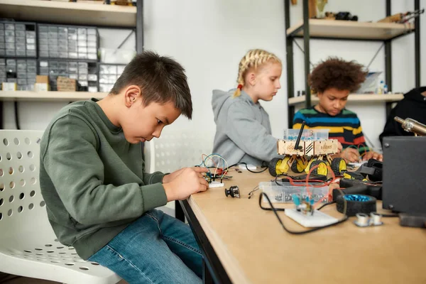 Exzellenz in jeder Erfahrung. Junge Techniker basteln Spielzeug in einem Technologiekurs. Kluge Kinder und Stammzellenerziehung. — Stockfoto