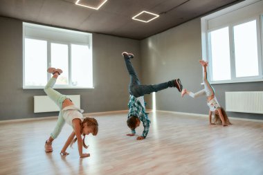 Breakdance savaşı. Küçük kızlar ve oğlanlar dans stüdyosunda koreografi dersinde el ele tutuşmayı öğreniyorlar.