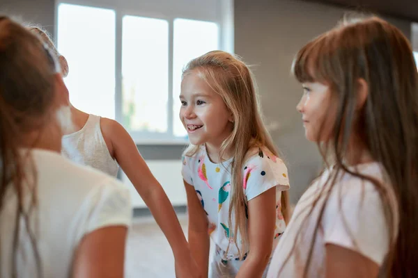 Lyckliga barn. En grupp söta och positiva små flickor som pratar och ler när de står i dansstudion. Koreografi — Stockfoto