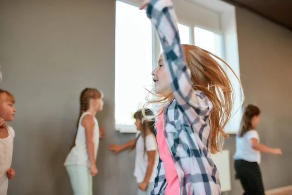 Uno stile di vita sano. Ritratto di una bambina felice che balla e si diverte mentre fa una lezione di coreografia. Gruppo di bambini che studiano nella scuola di danza — Foto Stock