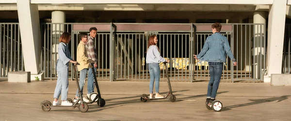 Campeones de la seguridad. Amigos alegres montando patinetas scooters y segways —  Fotos de Stock