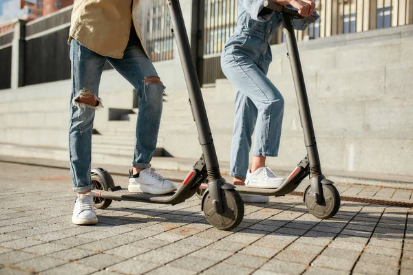 Vamos, vamos. Dos amigos se divierten conduciendo scooters eléctricos en un día soleado — Foto de Stock