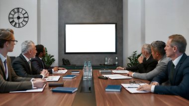 Skype call. Group of multicultural business people having video conference while sitting in the meeting room. Business team looking at screen