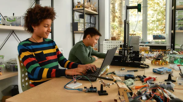 Límites de empuje. Estudiantes construyendo y aprendiendo a programar vehículos robóticos en una clase de robótica madre. Ciencia y educación . — Foto de Stock