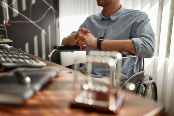 Cropped photo of a successful businessman in a wheelchair working at his workplace in the modern office. Disabled office worker — Stockfoto