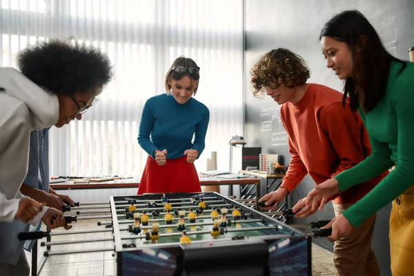 Together we are winners. Group of young and happy multicultural people in casual wear playing table soccer in the modern office. Office activities. Having fun together. Happy employees — Stok fotoğraf