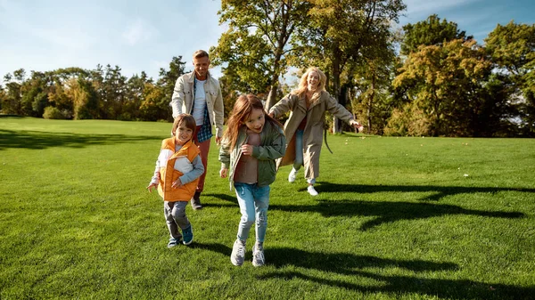 Sunny day. Excited family running outdoors on a sunny day — 스톡 사진