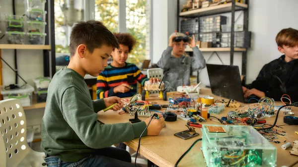 Imagine, create, participate. Young technicians building robots and vehicles, using soldering iron to join chips and wires, programming toys at a stem robotics class — Φωτογραφία Αρχείου