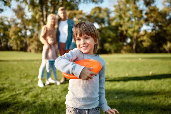 Vakantie modus. Kleine jongen speelt frisbee in het park op een zonnige dag — Stockfoto