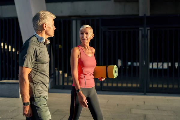 Healthy living. Active middle-aged couple in sports clothing going to exercise together outdoors — Zdjęcie stockowe