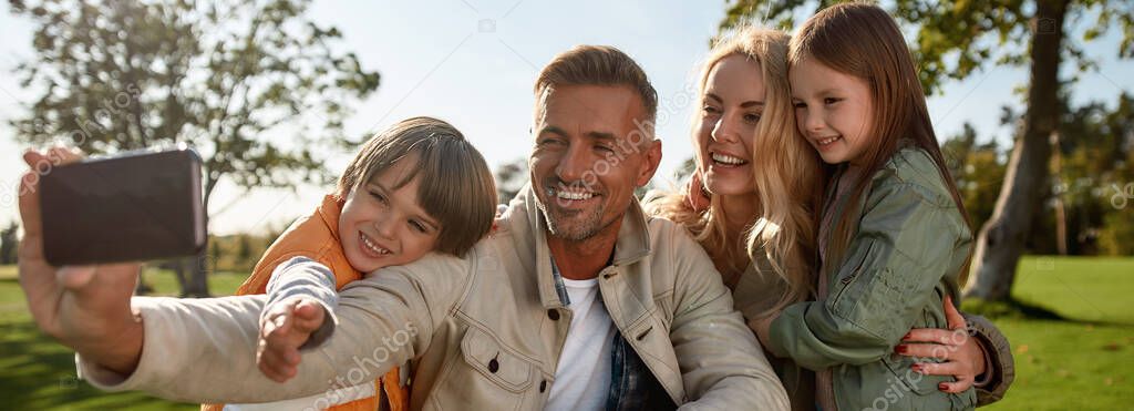 Lets make our portrait. Happy family taking selfies outdoors