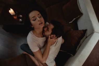 Ben seni istiyorum. Genç seksi erkek ve kadın kanepede sevişmeden önce öpüşüyorlar.