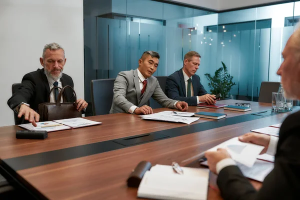 Equipe de negócios multicultural em desgaste formal discutindo novo contrato, tendo uma reunião no escritório moderno. Empresários a trabalhar em conjunto — Fotografia de Stock