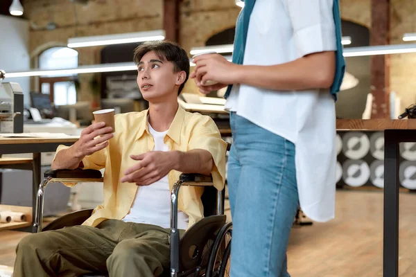 Bringing out the best in each other. Guy in a wheelchair working in the office — Stock Photo, Image