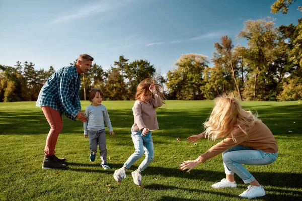 Çocukların akılda ve ruhta yetiştiği yer. Heyecanlı bir aile güneşli bir günde dışarıda eğleniyor. — Stok fotoğraf