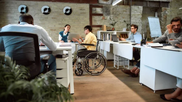 Samen bereiken we meer. Man in een rolstoel aan het werk in het kantoor — Stockfoto