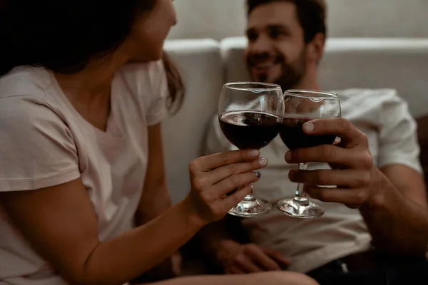 Noroc. Un cuplu fericit se relaxează, bea vin și vorbește în timp ce stă pe canapea acasă — Fotografie, imagine de stoc