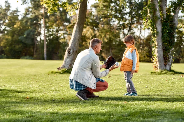 Çocuğunuza yardım edin. Baba, güneşli bir günde parkta beysbol öğretiyor. — Stok fotoğraf