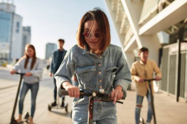 Yolların efsaneleri. Güneşli bir günde scooter ve segway kullanan bir grup arkadaş.