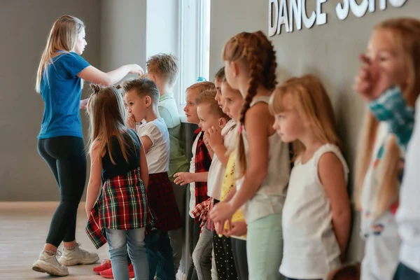 댄스 수업. 귀엽고 긍정적 인 학생들 과젊은 여성 교사가 댄스 스튜디오에 서 있는 모습입니다. 안 무개념 — 스톡 사진