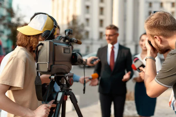 Nachrichten, bevor sie Nachrichten sind. Kameramann zeichnet Interview auf. Journalismus-Branche, Livestreaming-Konzept. — Stockfoto