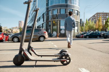 Burada araçlar mevcut. Sokakta duran kiralık elektrikli scooter.