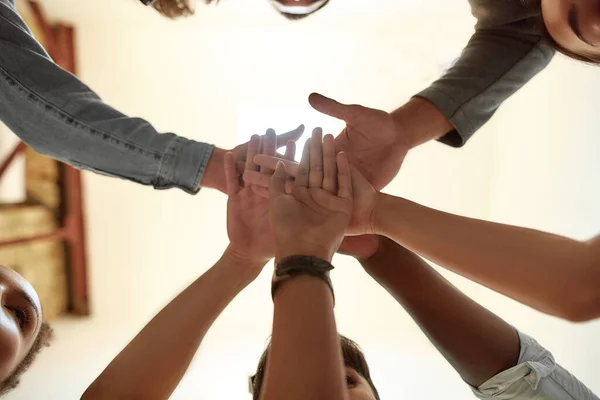 Tillsammans kan vi göra vad som helst. Bottom view of people holding hands together — Stockfoto