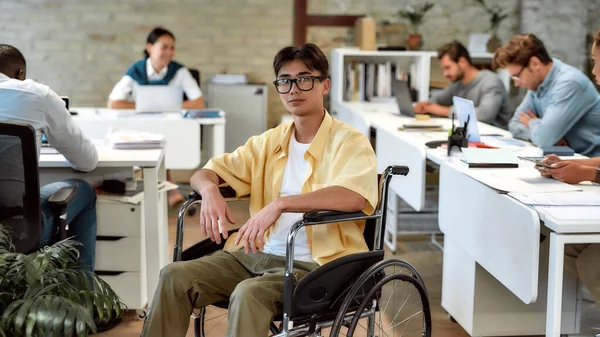 Werk voor jezelf, niet alleen. Man in een rolstoel aan het werk in het kantoor — Stockfoto