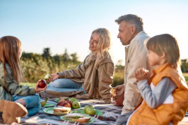 Yaklaşıyor. Mutlu aile güneşli bir günde parkta vakit geçiriyor.