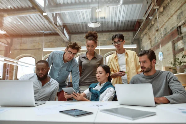 Rendi la tua attività più efficiente. Giovani uomini d'affari in abbigliamento casual che utilizzano tecnologie moderne e lavorano insieme su un nuovo progetto mentre siedono nell'ufficio creativo — Foto Stock