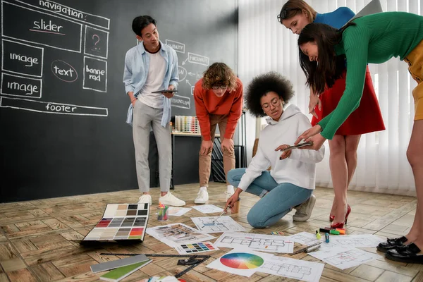 チームの仕事だ。現代オフィスの床に横たわるパレットから色を選択し、スケッチを議論インテリアデザイナーの専門家チームのグループ。クリエイティブエージェンシー — ストック写真