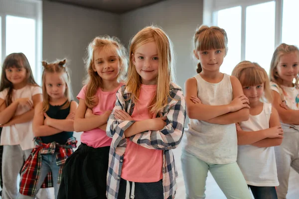 쿨 한 댄서들. 적극적 인 어린 소녀가 댄스 스튜디오에 서서 카메라 앞에서 웃으며 팔을 벌리고 있는 모습. 초심리학 수업 — 스톡 사진