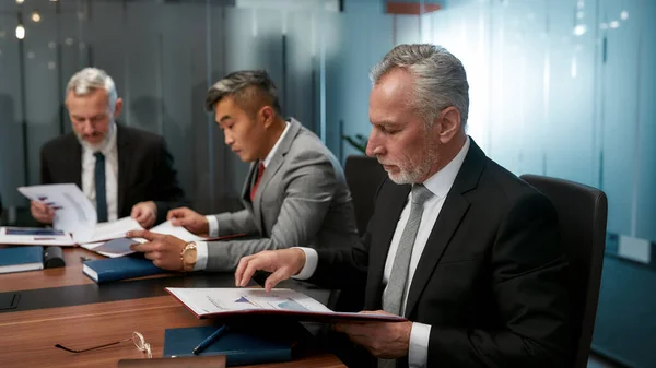 Papelada. Grupo de empresários multiculturais que lêem documentos durante uma reunião no escritório — Fotografia de Stock