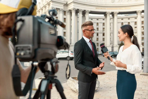 Journalistiek die onafhankelijk, eerlijk en waardig is. Cameraman en nieuwsverslaggever interviewen politicus. Journalistiek, live streaming concept. — Stockfoto