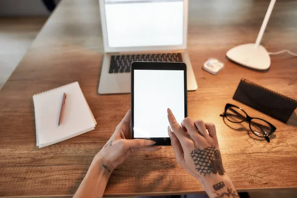 Vista dall'alto delle mani femminili con tatuaggi utilizzando tablet digitale. Tatuato businesswoan seduta sul suo posto di lavoro — Foto Stock