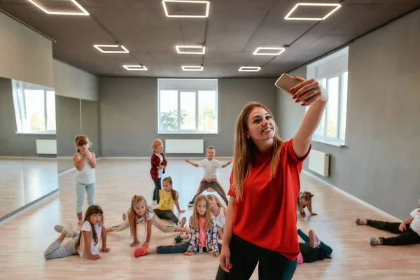 Ευτυχία είναι ο χορός. Νέος και θετικός δάσκαλος χορού βγάζει σέλφι με παιδιά ενώ έχει μάθημα χορογραφίας — Φωτογραφία Αρχείου