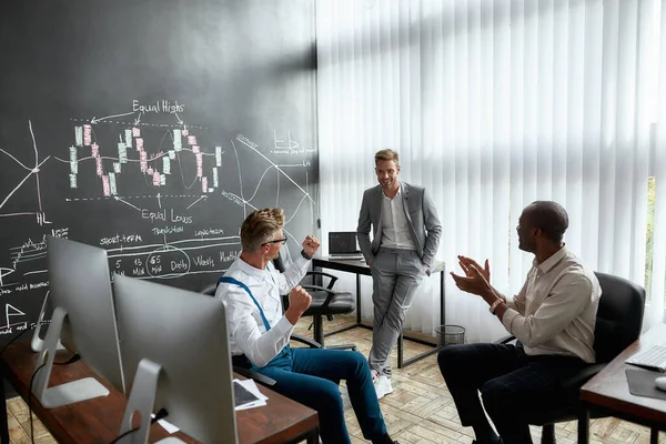 Obtenga su título de negocios aquí. Diversos empleados, comerciantes discutiendo la estrategia de trabajo, mientras que hablar con un colega de pie cerca de pizarra llena de gráficos. Disparo horizontal —  Fotos de Stock