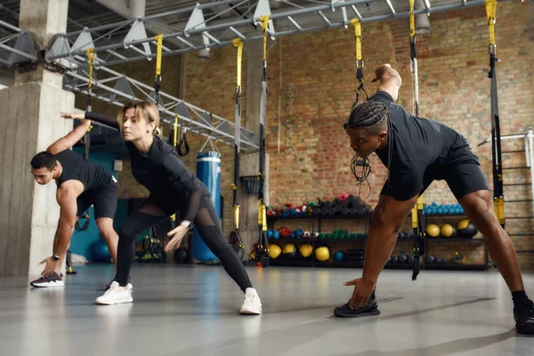 Apto para toda la vida. Foto completa de hombres y mujeres atléticos en ropa deportiva negra trabajando juntos en el gimnasio industrial —  Fotos de Stock