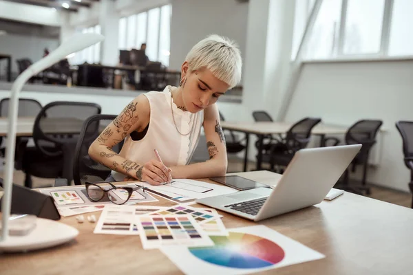 Yeni bir şey yaratıyorum. Genç ve güzel, yaratıcı kadın tasarımcı. Ofisinde çalışırken çizim yapıyor. — Stok fotoğraf