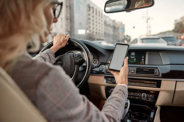 E-mail importante. Visão traseira da bela mulher de negócios usando seu smartphone enquanto dirige um carro — Fotografia de Stock