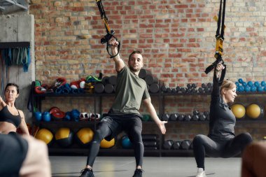 Acele et. Endüstriyel jimnastik salonunda spor yapan erkek ve kadınların portresi. şınav, grup çalışması konsepti