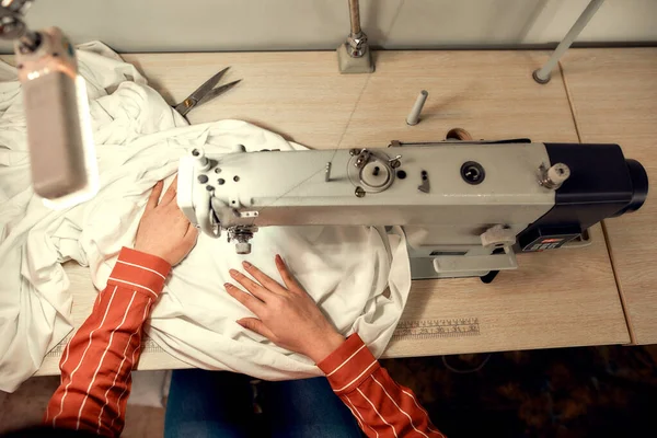 Make It Sew. Top view of woman seamstress sitting and sewing. Dressmaker working on the sewing machine. Tailor making a garment in her workplace — Stock Photo, Image