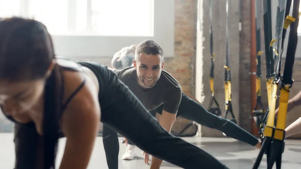 건강을 경험하라. 웃는 코카서스 남자가 산업 체육관에서 체력 훈련 운동을 하는 모습. 스트립, 그룹 작업 컨셉트 — 스톡 사진