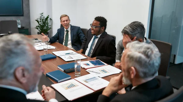 Un equipo exitoso. Gente de negocios multicultural en ropa formal discutiendo algo mientras tienen una reunión en la oficina moderna — Foto de Stock