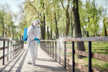 Şehir temizlikçileri. Covid19 virüsünün ortaya çıkmasından dolayı şehir parkının temizlenmesi, temizlenmesi ve dezenfekte edilmesi. Koruyucu giysiler ve maskeler konusunda uzman ekip iş başında.