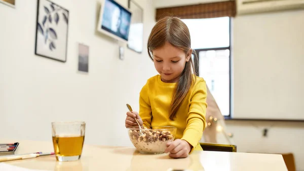 Início do dia. Caucasiano bonito menina vai comer bolas de cereais com leite para seu café da manhã ou almoço — Fotografia de Stock