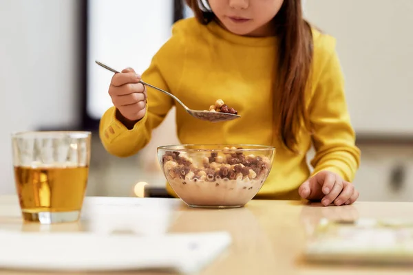 Κάτι τραγανό και τραγανό. Καλλιεργημένη φωτογραφία του καυκάσιου χαριτωμένο κοριτσάκι τρώει μπάλες δημητριακών με γάλα για πρωινό ή μεσημεριανό γεύμα της — Φωτογραφία Αρχείου